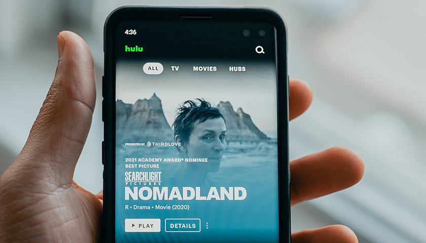 Holding a phone with Hulu on the screen