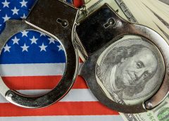 American flag with handcuffs and $100 bills