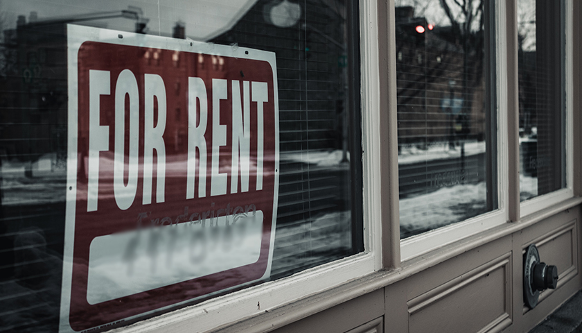 "For Rent" sign in window of building