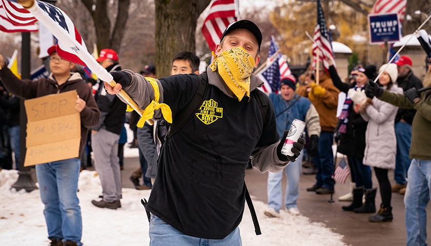 A member of the "Proud Boys" waves a flag at a "Stop The Steal" rally outside the Minnesota Governor's mansion on November 14th, 2020.