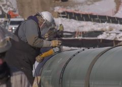 Man grinding a large pipe on a worksite