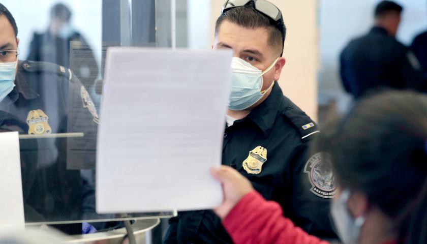 Customs Border Protection agent and migrant showing papers